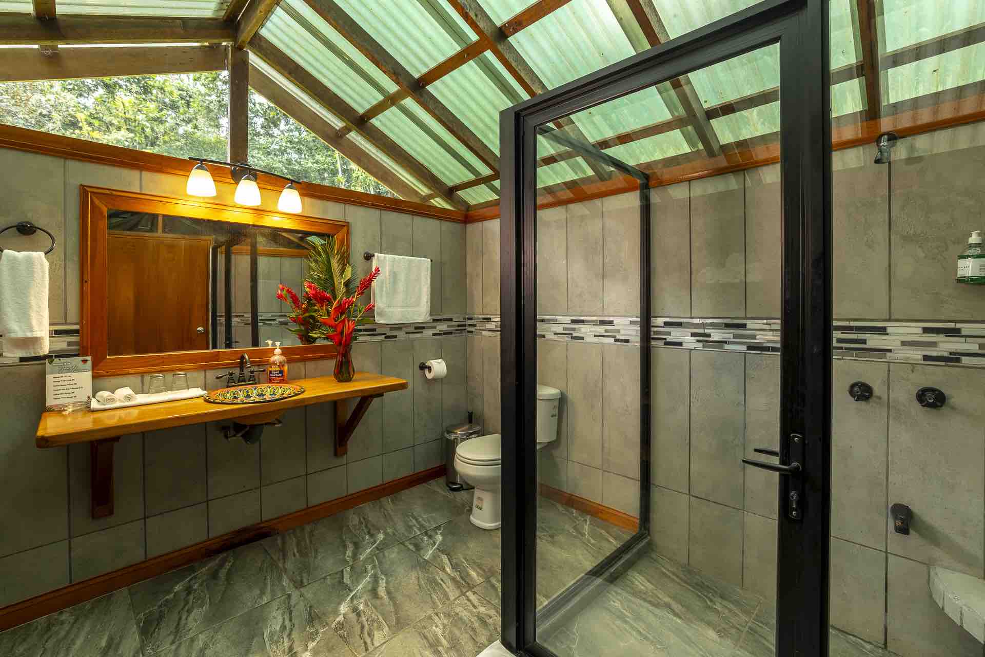 Safari tent bathroom with walk-in glass shower under a skylight roof